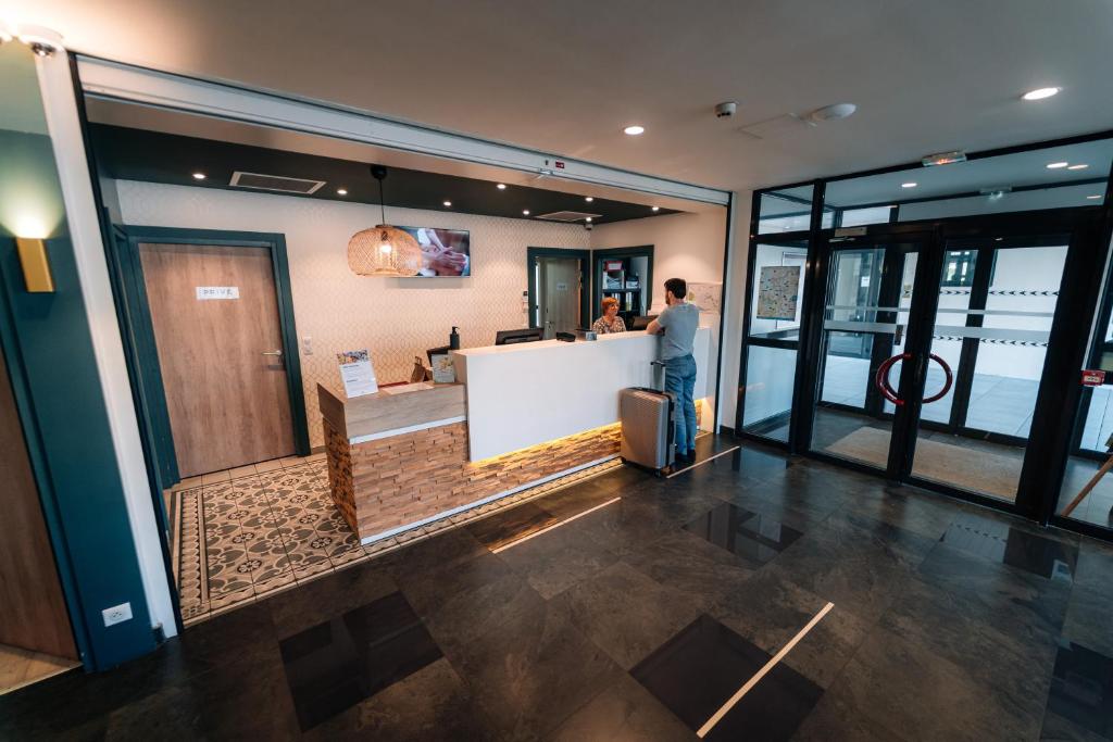 艾克斯莱班Les Loges du Park的一名男子站在大楼柜台前