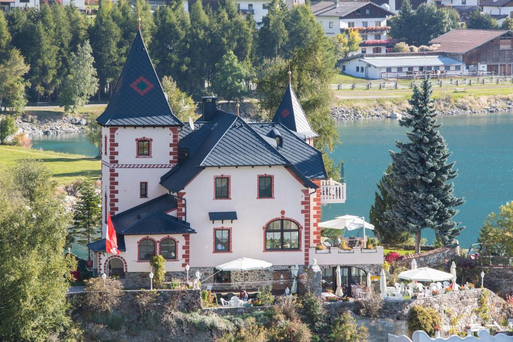 雷西亚Hotel Schloesschen am See的水中岛上的房屋
