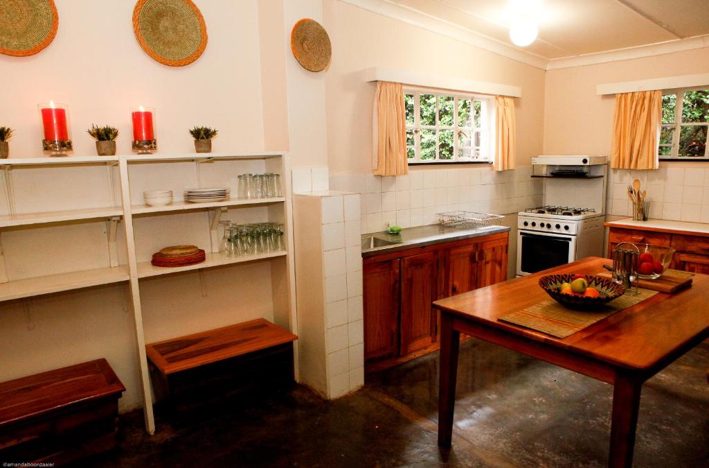 LobambaDown Gran's Self-Catering Cottage的厨房配有木桌和木桌四柱四柱床