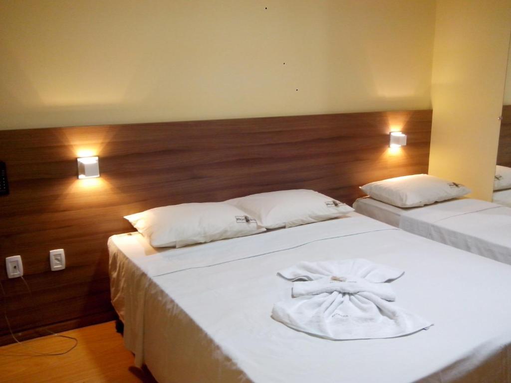 CastanhalEstação Hotel的一间卧室配有两张带白色床单的床