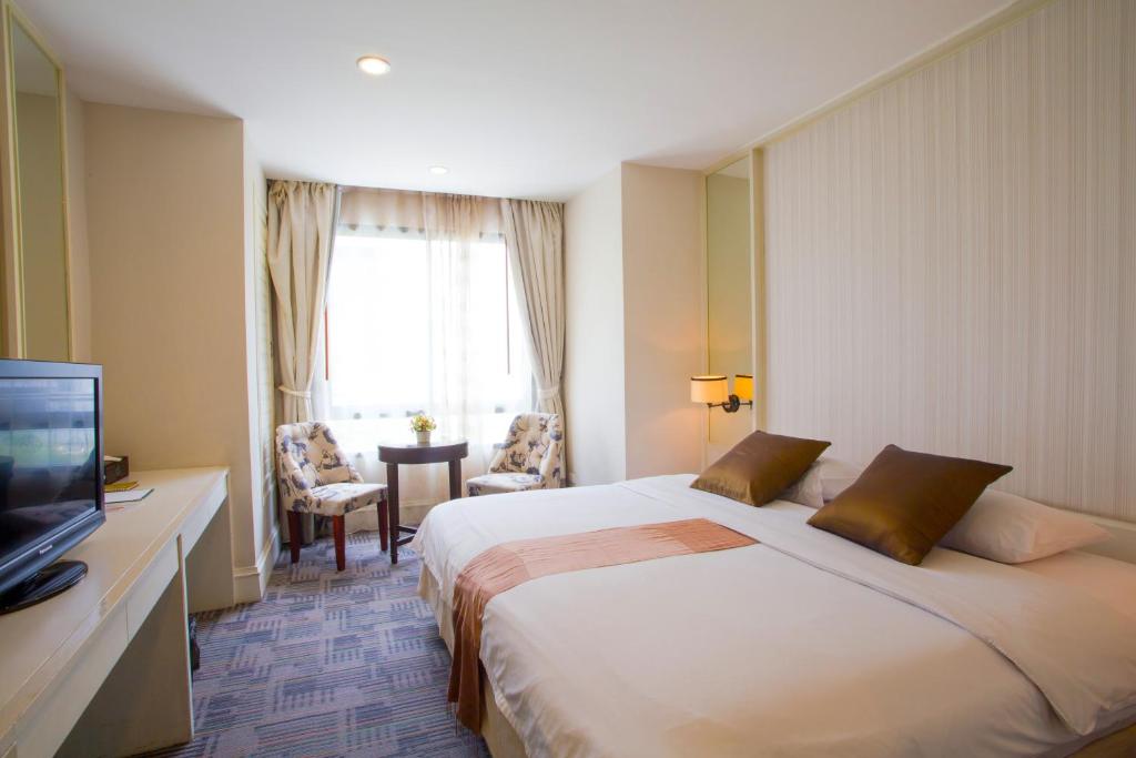 曼谷曼谷阿芙罗宾馆的酒店客房设有一张大床和一台电视。