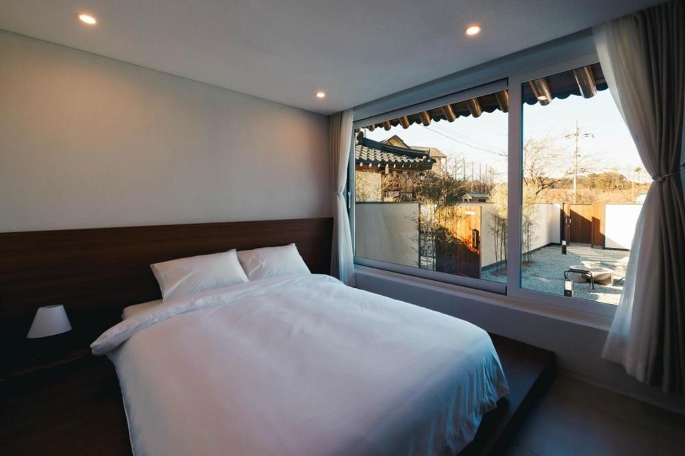 江陵市Gangneung Jeodong Hanok Pension newly built的一间带床和大窗户的卧室