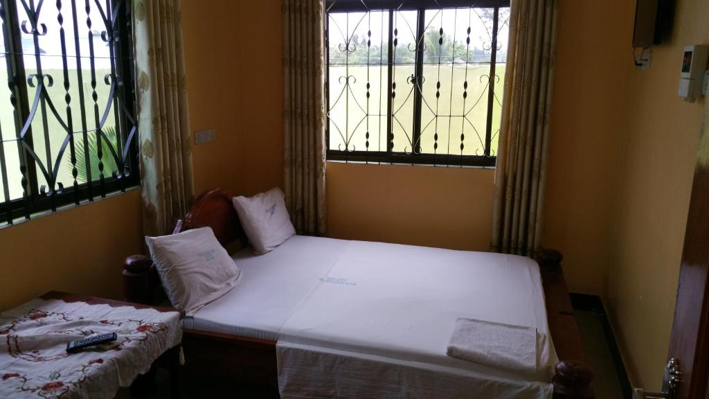 达累斯萨拉姆Mauya Executive Lodge的一间小卧室,配有床和2个窗户