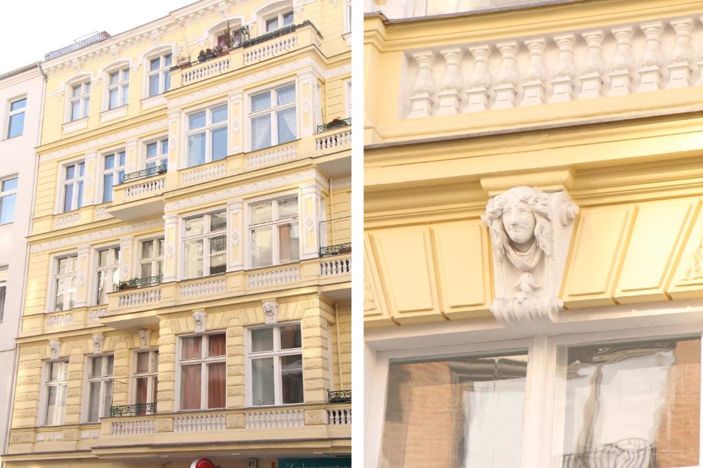 柏林Stars Berlin Apartments Zillestraße的前面有雕像的黄色建筑