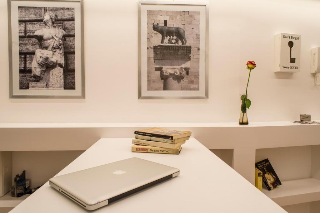 罗马米拉比利亚雅邦罗马住宿加早餐旅馆的一台笔记本电脑坐在桌子上,备有书籍