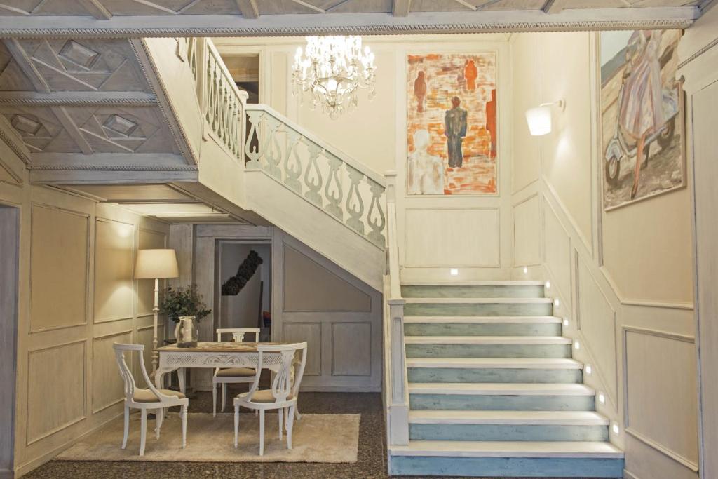 萨莫拉Ares Hotel的楼梯,房间带桌子和吊灯