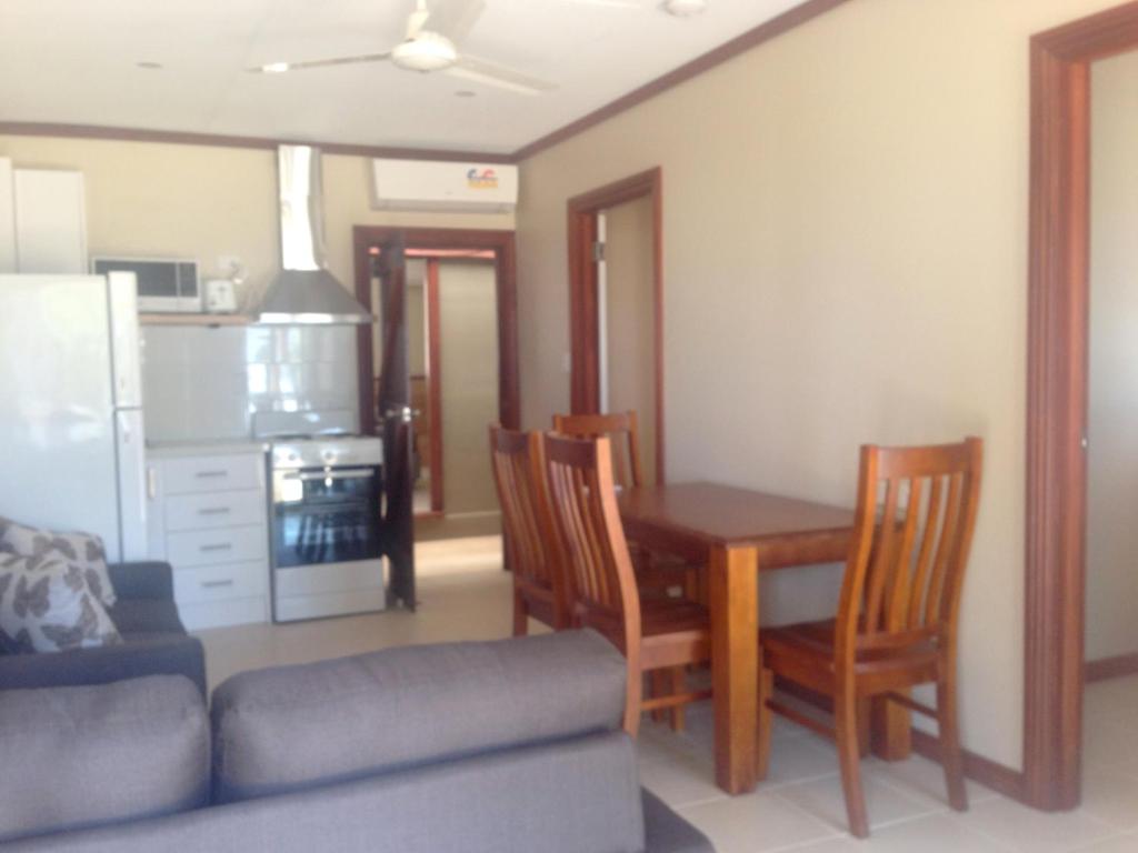 飞鱼湾科科斯帕当山林小屋公寓的一间带桌椅的客厅和一间厨房