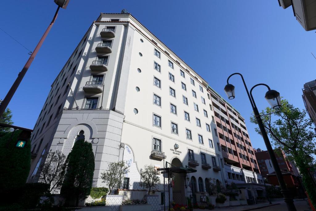 长崎长崎蒙特利酒店的白色的建筑,旁边设有阳台