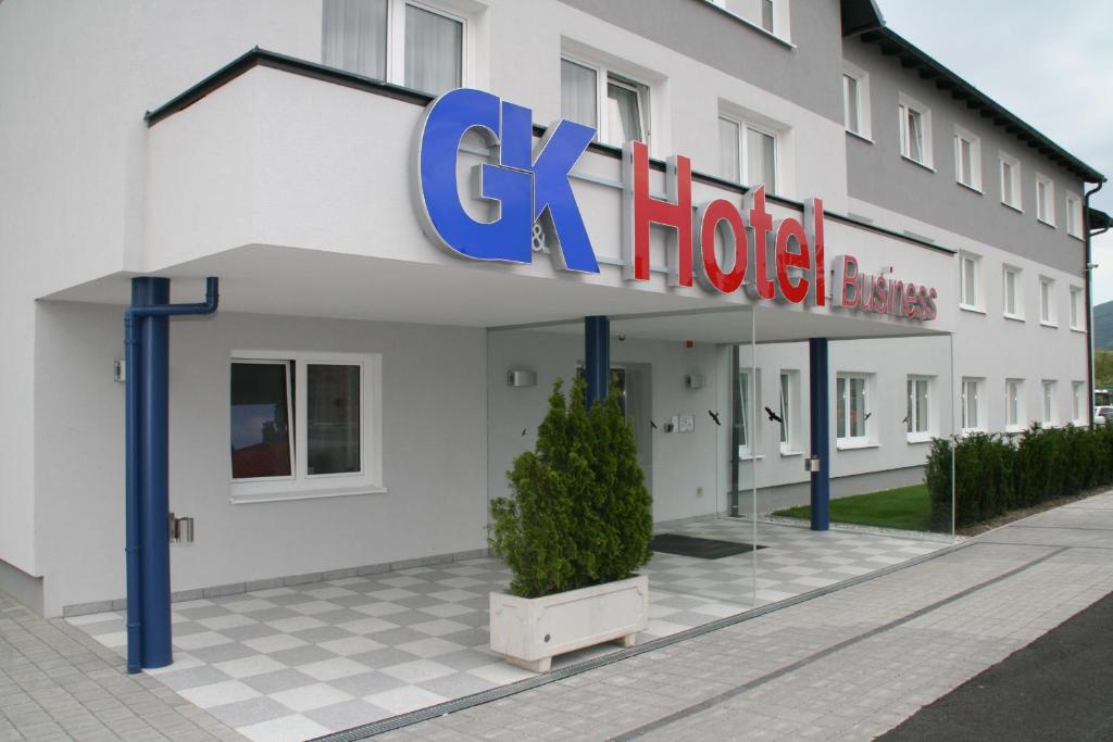 贡特拉姆斯多夫G&K酒店的一座白色的建筑,上面标有酒店标志