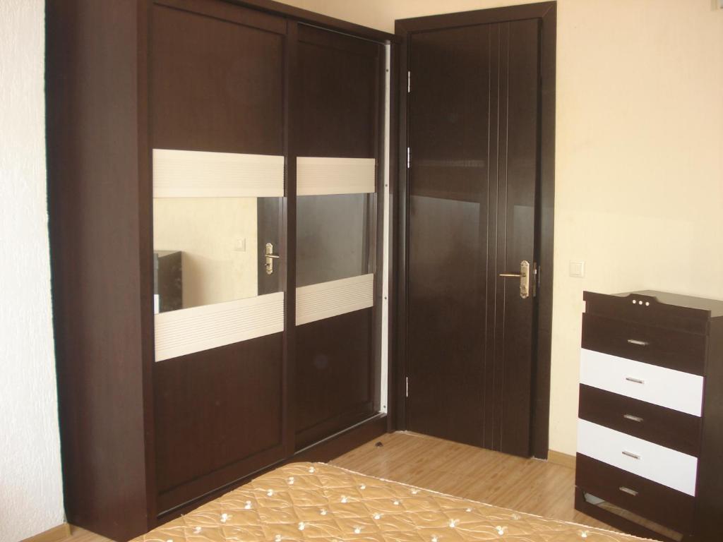 乌雷基Apartment Zhemchuzhina Ureki的一间卧室设有大型木制衣柜和一张床