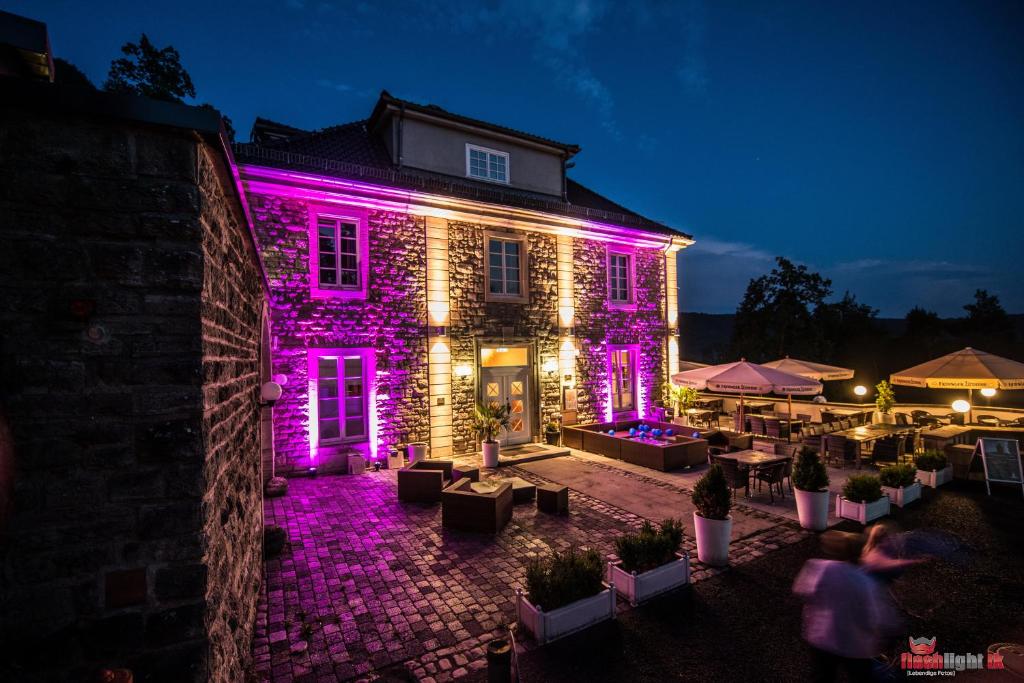 艾森纳赫埃森纳特贝格酒店的一座晚上有紫色灯光的建筑