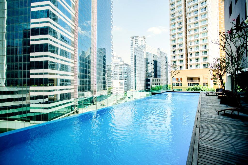吉隆坡吉隆坡翠绿山酒店的一座位于城市的游泳池,有高大的建筑