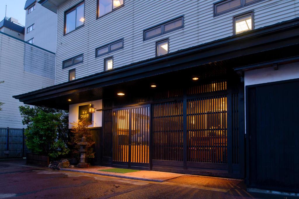 青森宿屋茶花酒店的一座前方有商店的建筑,其门打开