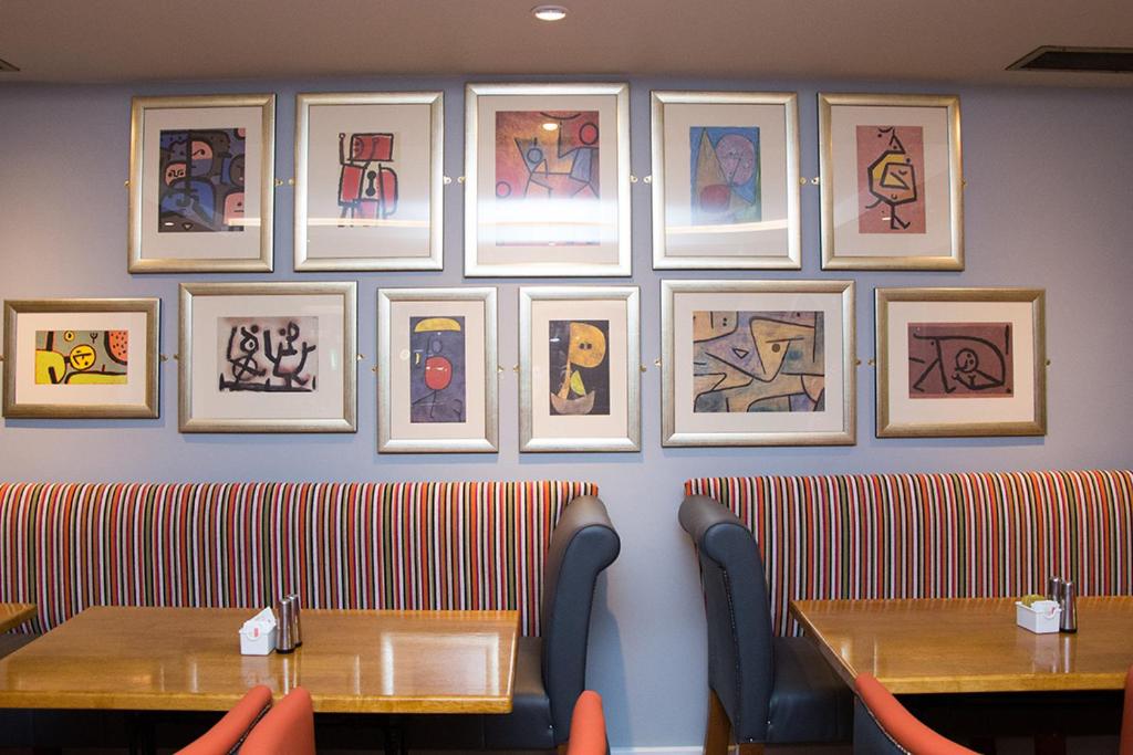 肯梅尔大卫茨宾馆的餐厅设有两张桌子,墙上挂有绘画作品