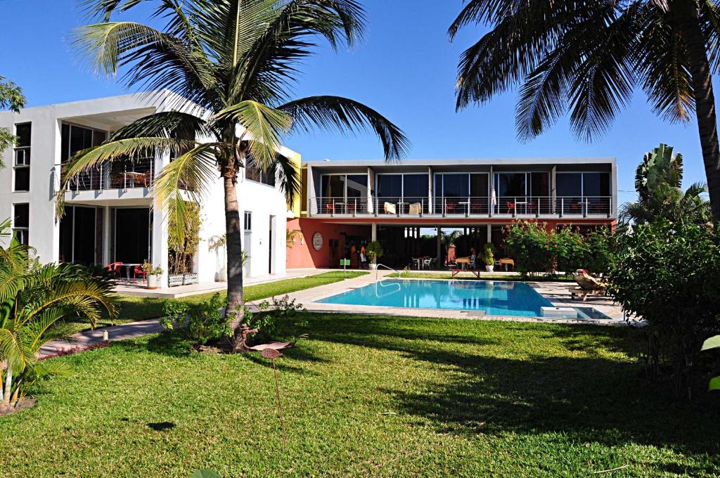 BrufutLeo's Beach Hotel - Adults Only的一座带游泳池和棕榈树的建筑
