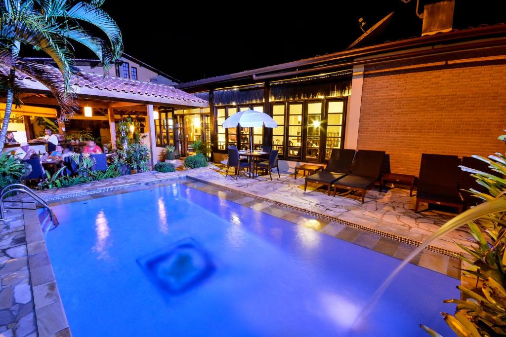 乌巴图巴艾斯特拉格慕卡萨格兰德波萨达酒店的夜间在房子前面的游泳池