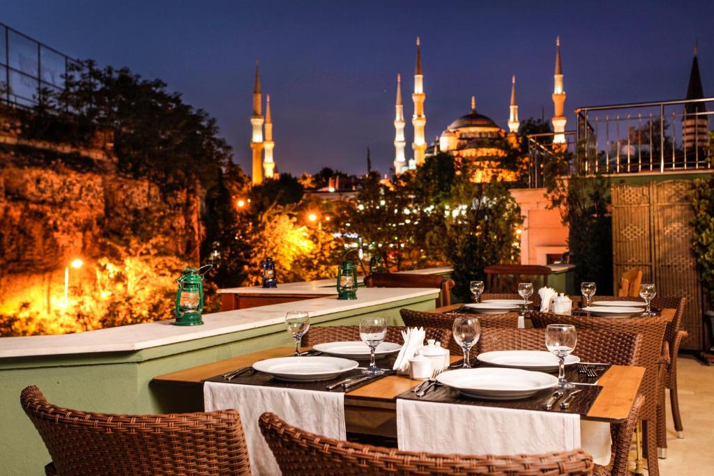 伊斯坦布尔犹太树特殊类别酒店的餐厅设有桌椅,享有蓝色清真寺的景致