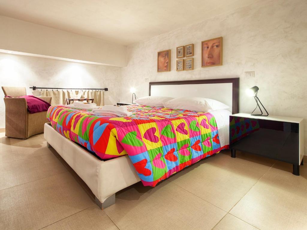 罗马HT Residence Maximus的一间卧室配有一张大床和色彩缤纷的毯子