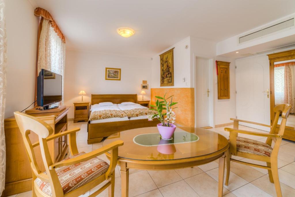 塞格德卡塔酒店的客厅配有桌子和床。