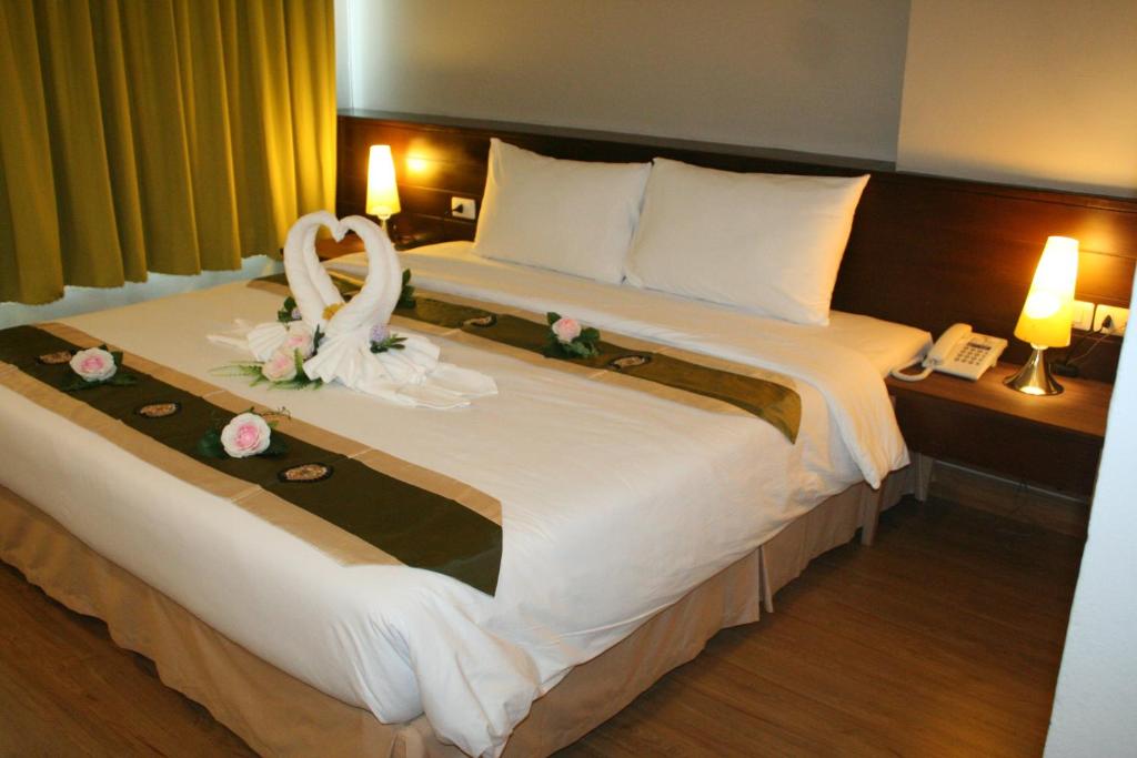 合艾阿罗哈合艾酒店的酒店客房设有一张大床,上面装有婚纱
