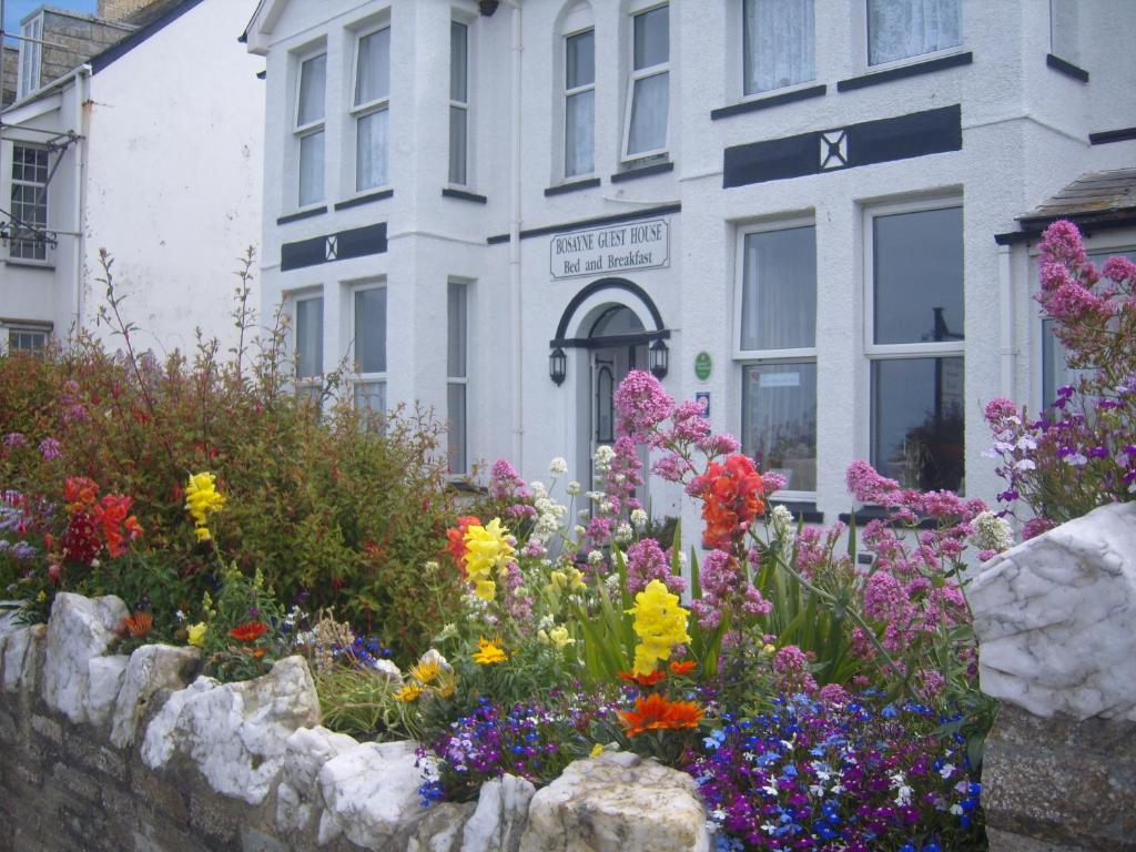 廷塔杰尔Bosayne Guest House的一座建筑前的鲜花花园