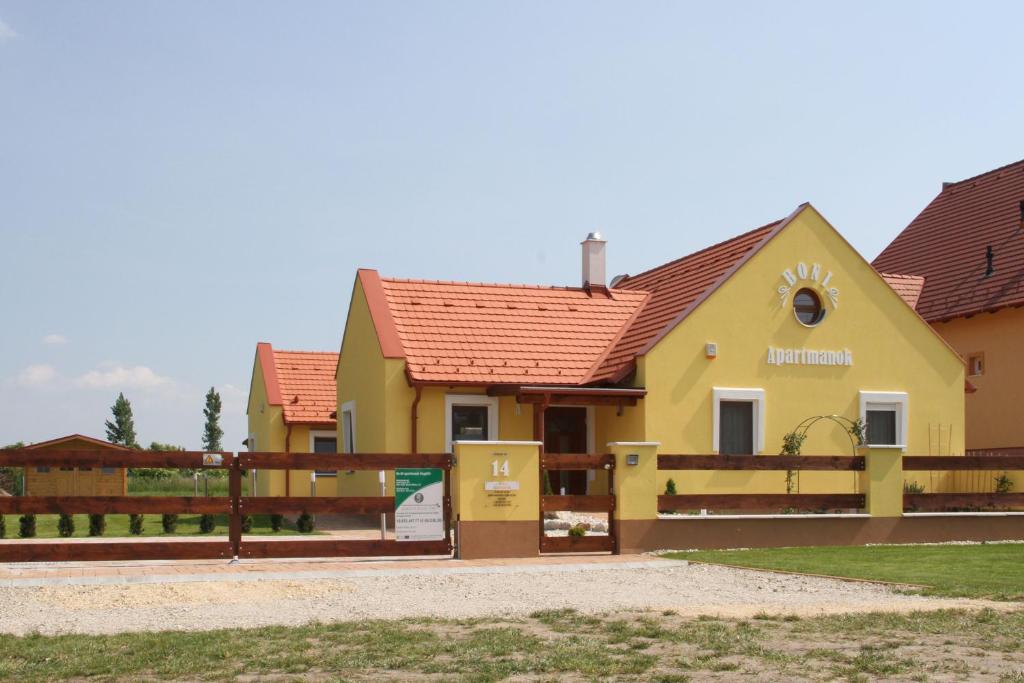 海吉克BONI APARTMAN Hegykő的黄色的房屋,有红色的屋顶