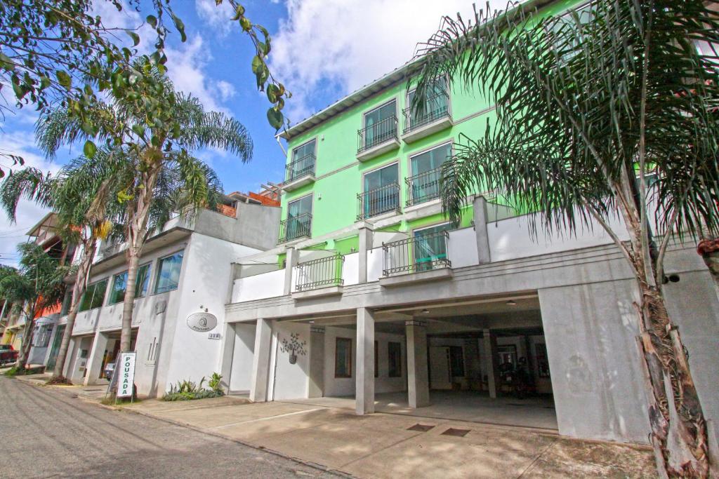 特雷索波利斯冒险旅馆的一座绿色的白色建筑,前面有棕榈树