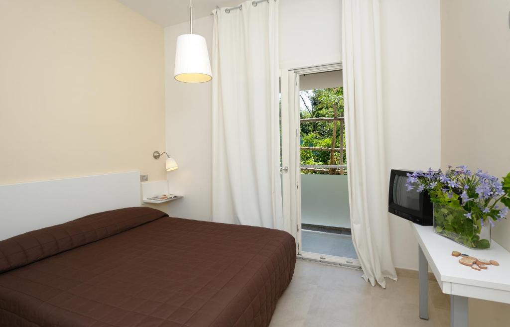 马奥莱甜蜜生活公寓酒店的一间卧室配有一张床、一台电视和一个窗口