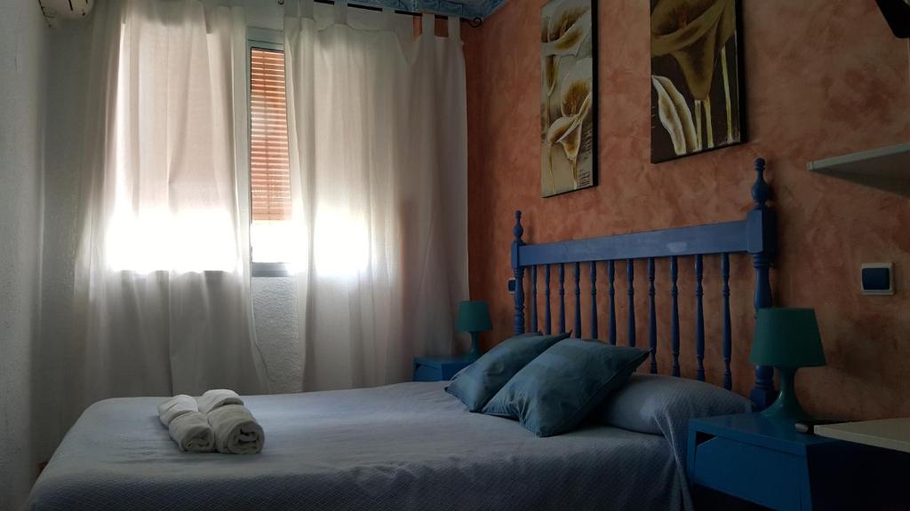 塞维利亚吉拉尔蒂拉酒店的一间卧室配有一张床,上面有两条毛巾