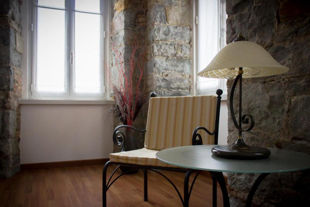 的里雅斯特特蕾西娅泰勒公寓式酒店的桌子,带灯,椅子,桌子,带灯