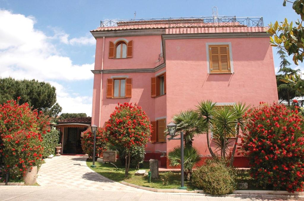 罗马阿科迪塔沃蒂诺酒店的前面有红花的粉红色建筑