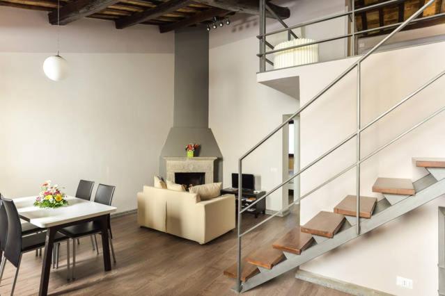 罗马纳沃纳鲁本斯公寓的客厅设有楼梯、桌子和沙发