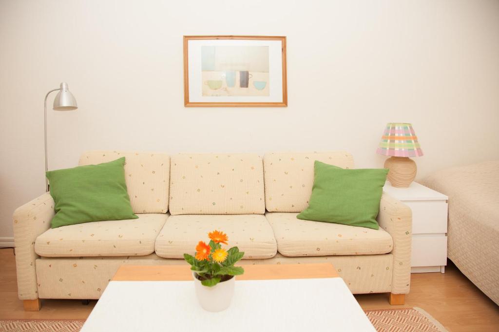 赫尔辛基Eskolampi的客厅配有白色沙发和绿色枕头。