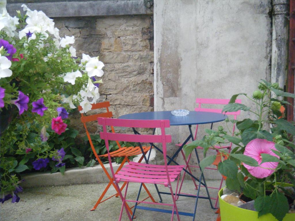 隆勒索涅甘贝塔酒店的三把椅子和一张桌子,还有一些花