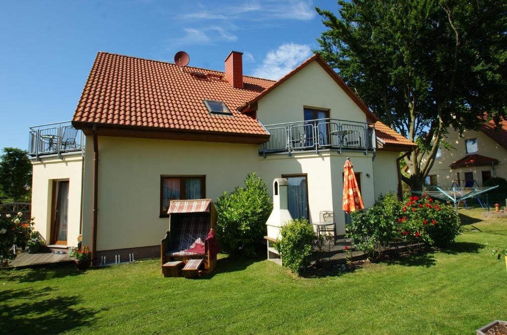 科瑟罗Ferienwohnung Koserow的一座白色的小房子,带草坪四柱形四柱形