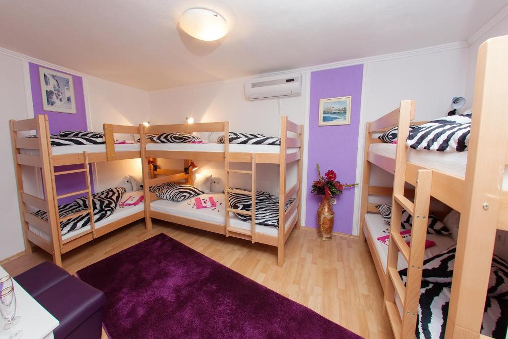 莫斯塔尔米瑞旅舍的一间设有三张双层床和紫色墙壁的客房