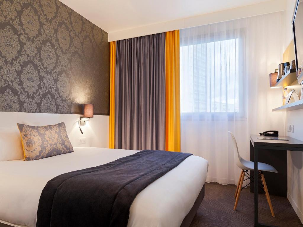 圣皮耶尔代科尔普基里亚德图尔圣皮埃尔库尔车站酒店的配有一张床、一张书桌和一扇窗户的酒店客房
