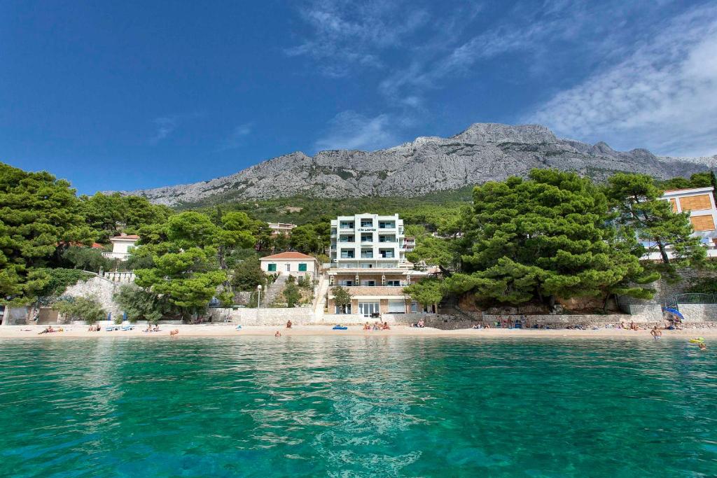 布雷拉Apartments Villa Loznica的享有海滩美景,背景为山脉