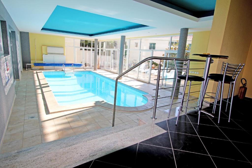 克勒克Apartments Villa Ceres的一个带椅子和蓝伞的游泳池