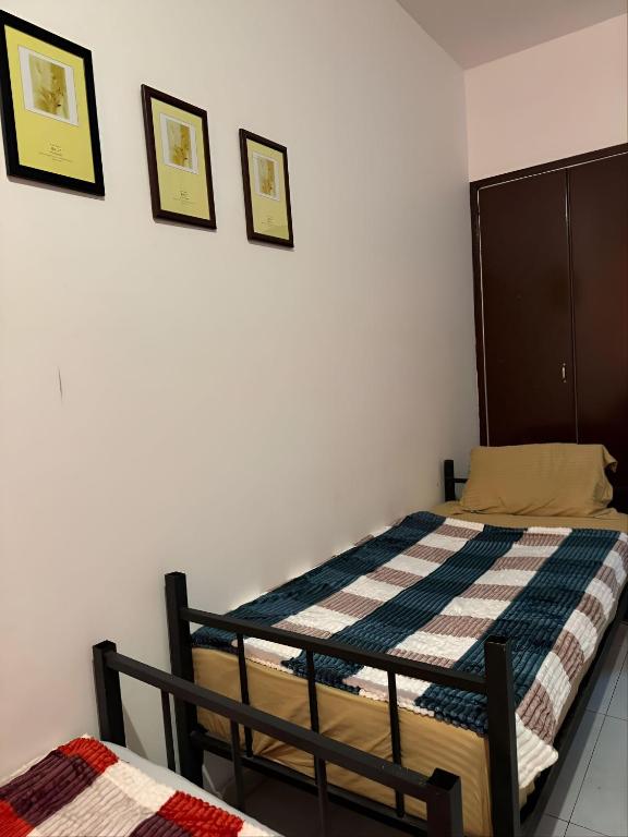 阿布扎比Abu Dhabi Bed Space的一间卧室，墙上有两张床和两幅画