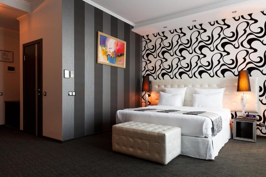 克拉斯诺达尔迈如泰尔酒店的卧室配有一张白色大床和条纹墙