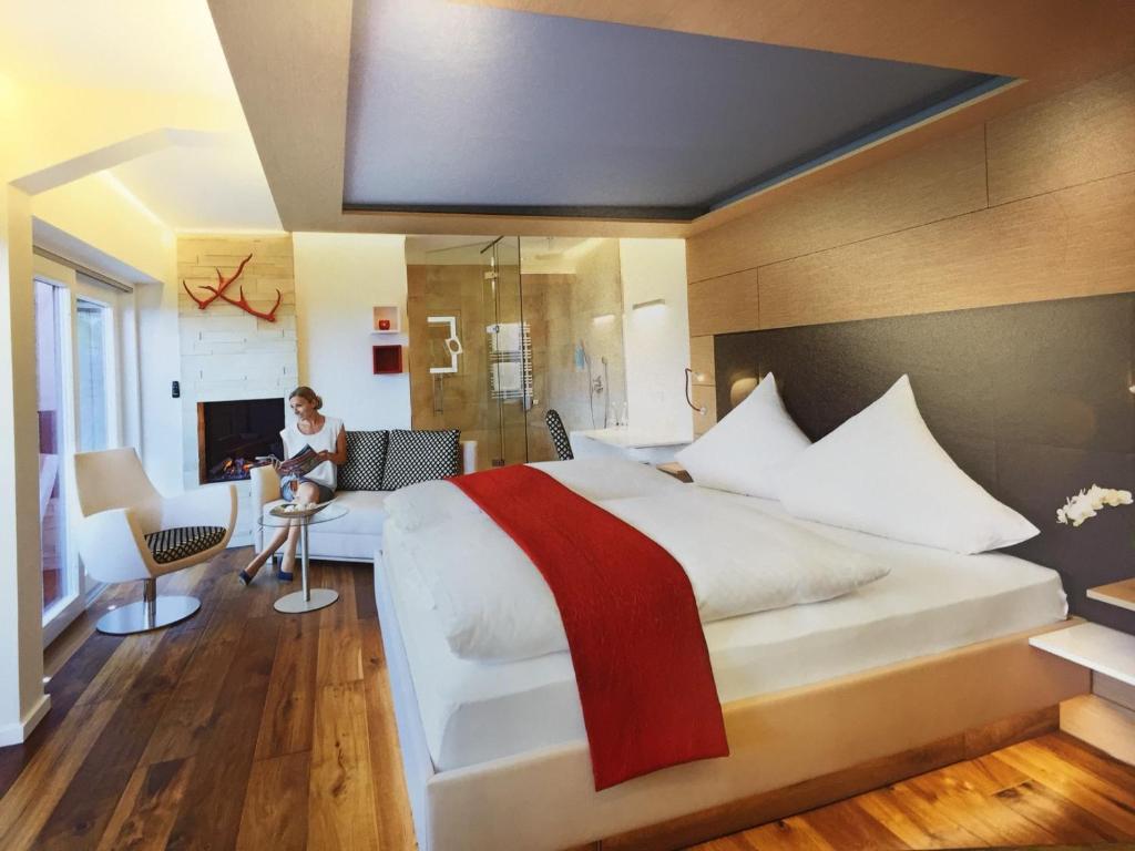 布尔雅格斯泰格酒店的一间酒店客房,配有一张大床和一张桌子上的女人