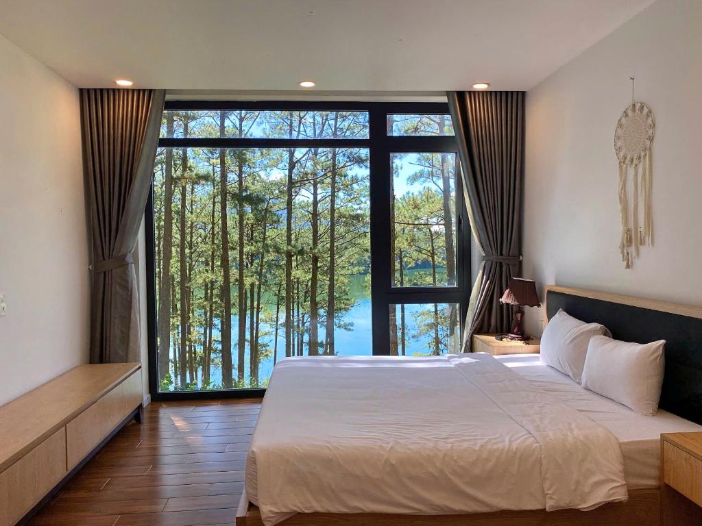 大叻Lan Anh Villas Resort的一间带大床和大窗户的卧室