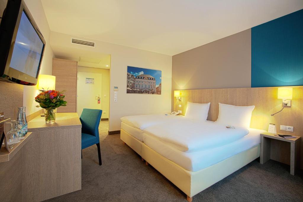 波恩普瑞斯登特酒店的酒店客房设有一张大床和一台电视。