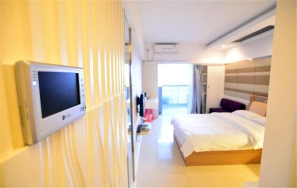 南宁南宁青舟房屋租赁式公寓的配有一张床和一台平面电视的酒店客房
