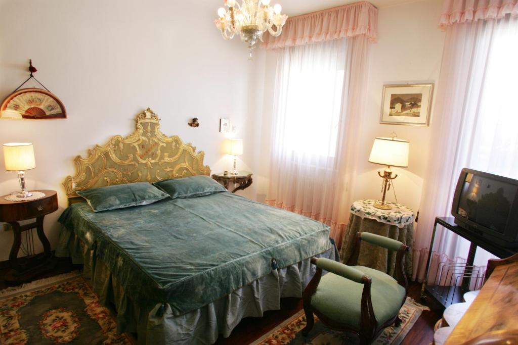 威尼斯丽都格里希恩菲奥里托住宿加早餐酒店的一间卧室配有一张带绿色棉被的床和一台电视。