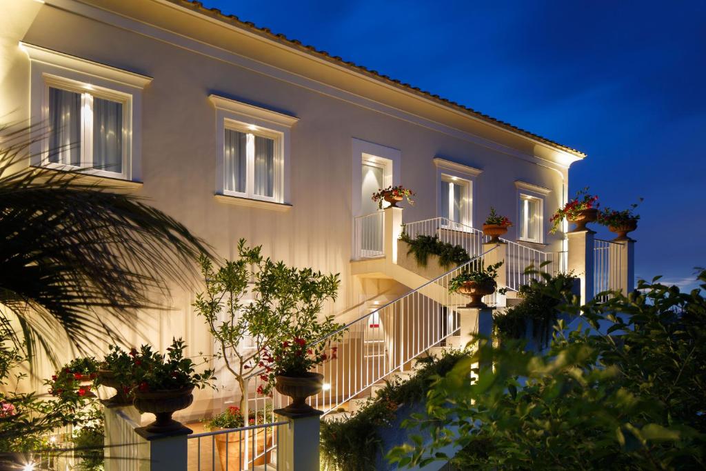 圣安吉洛多恩卡米洛别墅旅馆的一座晚上在阳台上种有盆栽植物的建筑