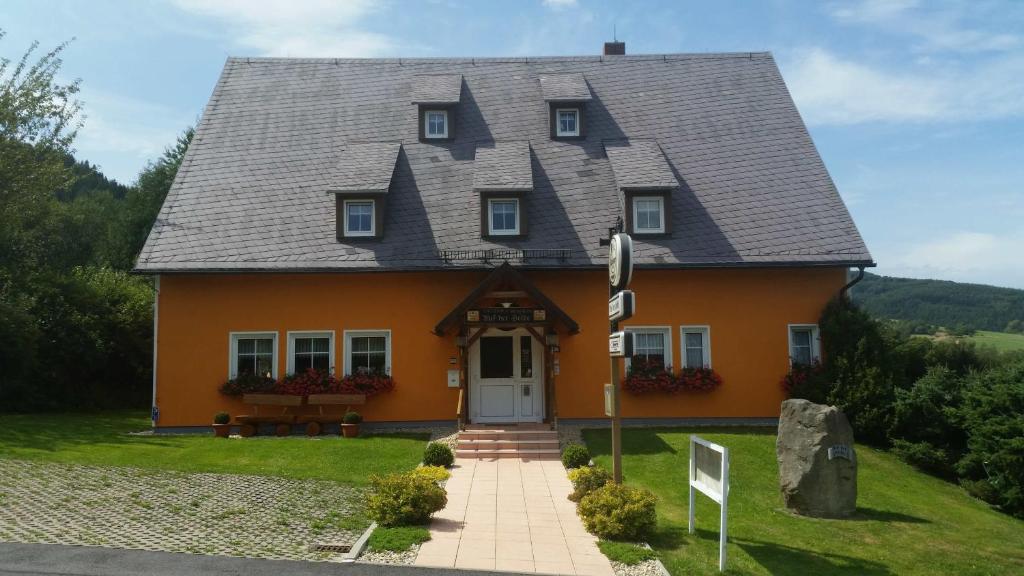 瓦尔特尔斯多夫Auf der Heide Gasthof & Pension的一座带灰色屋顶的橙色房子
