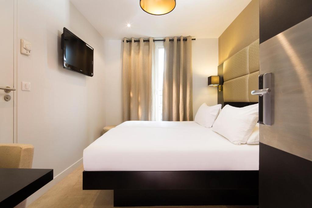 巴黎马莱驿站酒店的卧室配有一张白色大床和电视。