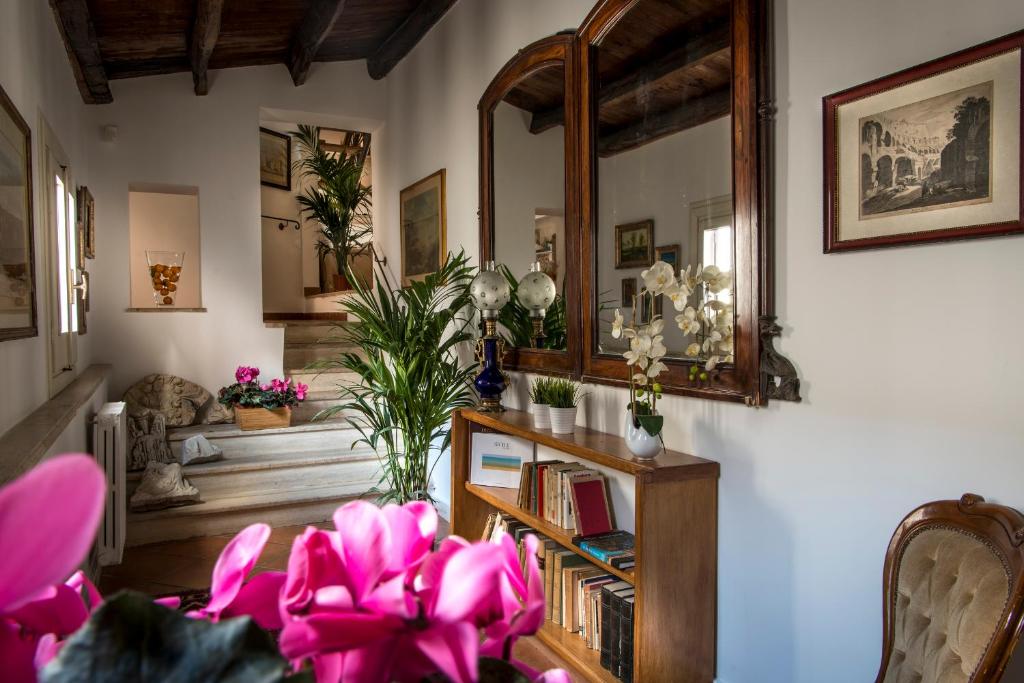 巴勒莫迪莫拉托伦姆扎公寓的客厅配有粉红色的鲜花和镜子